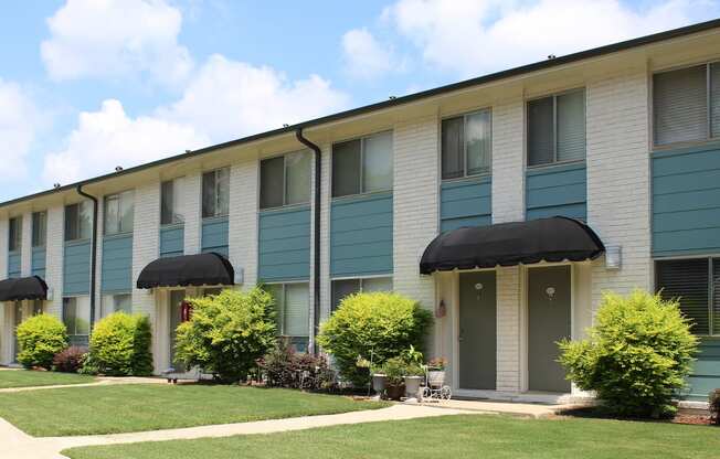 well-kept Sherwood Park Apartment homes exterior with fresh paint, door awnings, and neat landscaping  at Huntsville Landing Apartments, Alabama, 35806