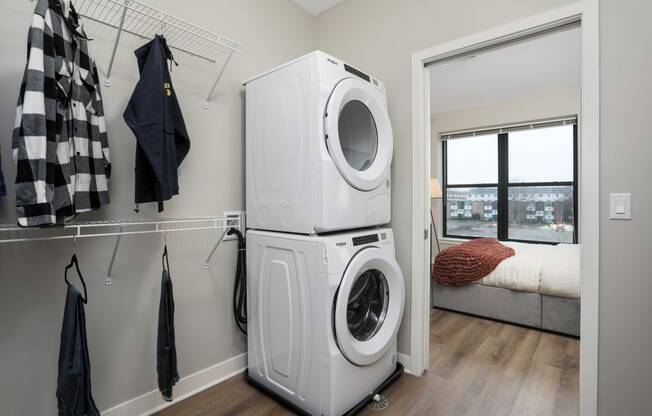 a white washer and dryer in a room with a closet and a window