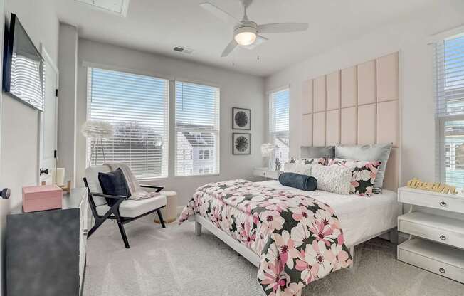 A bedroom with a large bed and a ceiling fan.