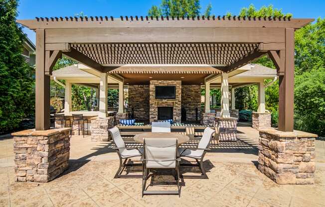 A patio with a table and chairs under a pergola.