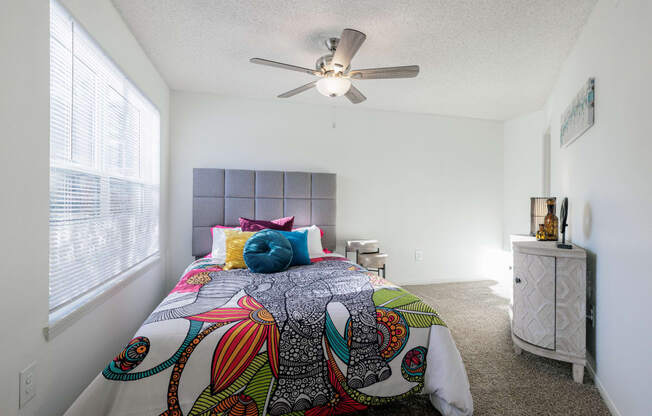 a bedroom with a large bed and a ceiling fan