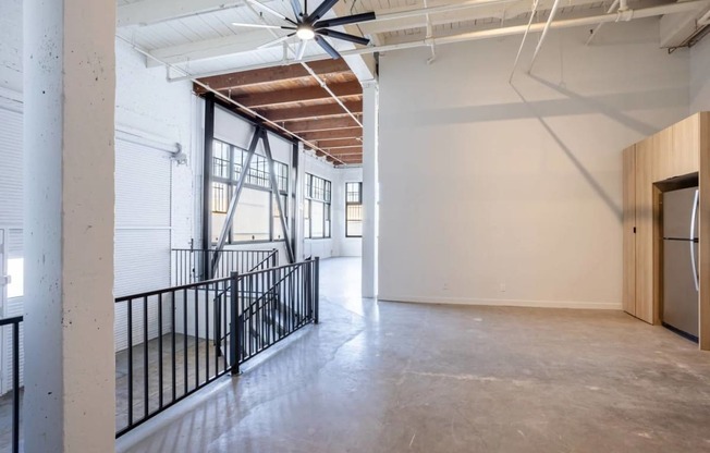 the lobby of a building with a concrete floor and white walls