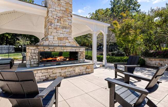 the outdoor patio has a stone fireplace and seating areas at View at Lake Lynn, Raleigh North Carolina