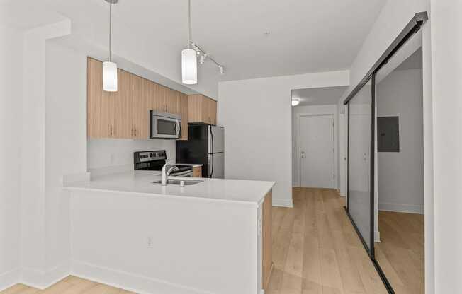 A kitchen with a white counter and wooden cabinets.