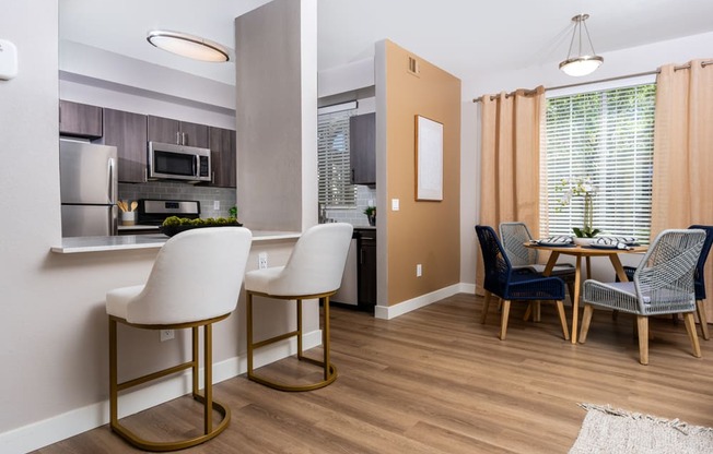 a living room and kitchen with a dining room table and chairs