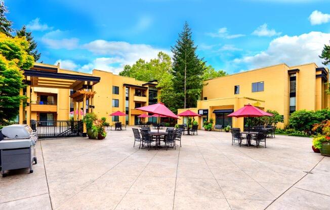 12 Central Square outdoor patio with tables, greenery and red umbrellas