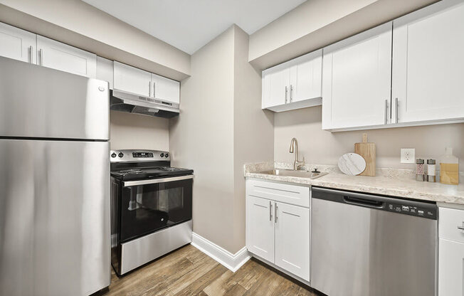 Model Kitchen with White Cabinets and Wood-Style Flooring at Heights at Marlborough Apartments located in Marlborough, MA.