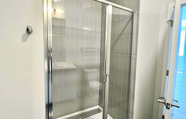 A glass shower stall with a door and a handle.