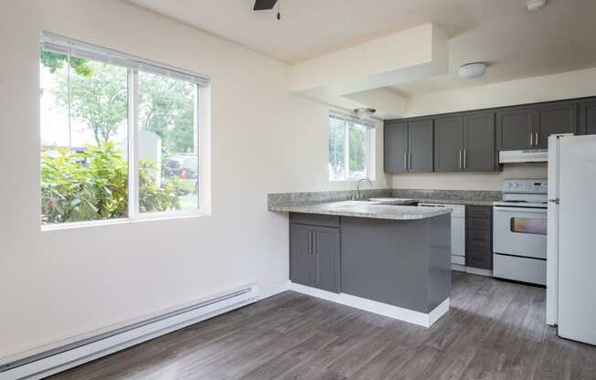 a kitchen with gray cabinets and white appliances