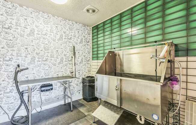 A kitchen with a stainless steel sink and a green trash can.