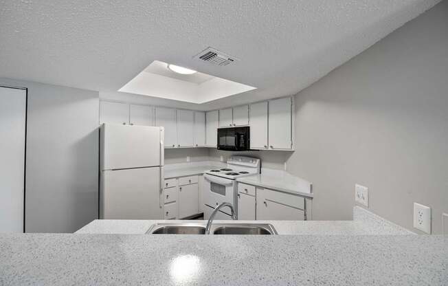 A kitchen with white cabinets and appliances.