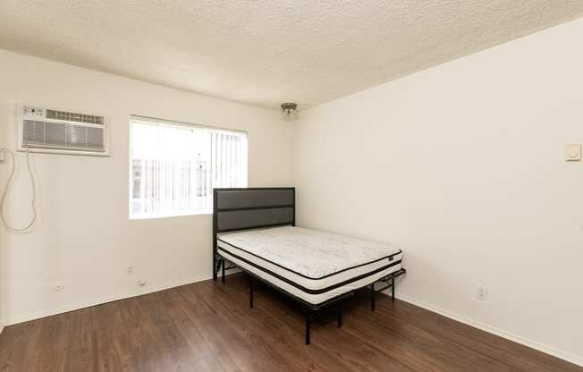 Studio with Hardwood Floors, Mirrored Wardrobe Closet and Kitchen with White Cabinets