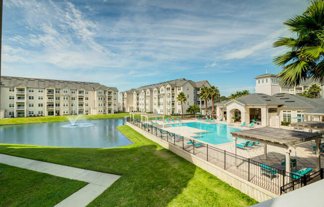 a swimming pool with a fountain and a gazebo in front of a building