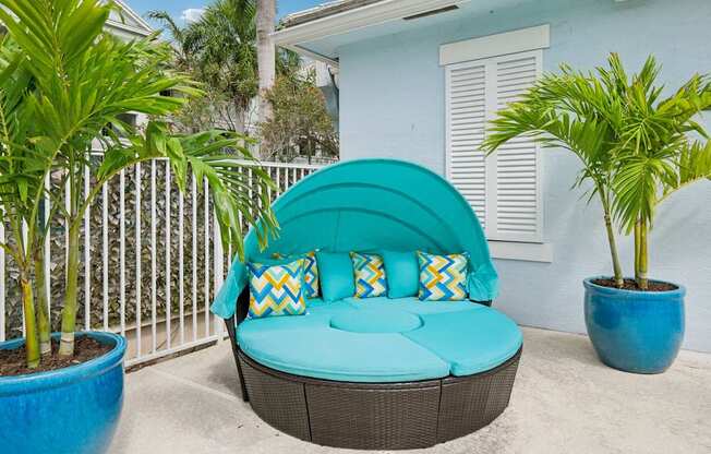 A blue couch with a white fence in the background.