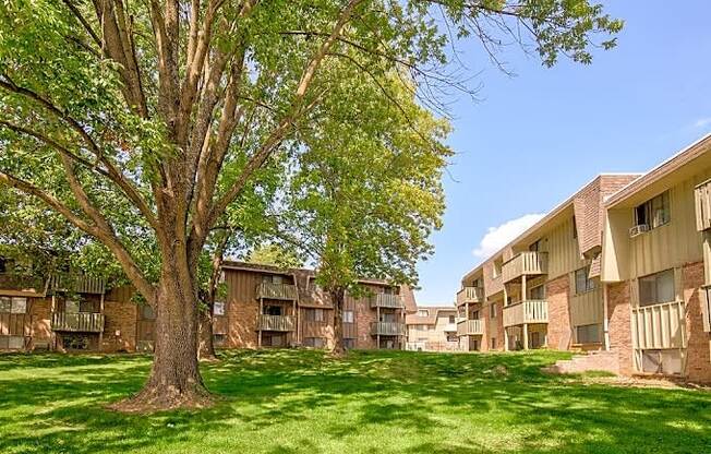 an apartment building with green grass and trees