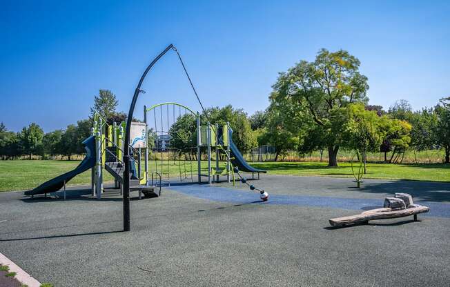 A playground with a green slide and a blue slide.