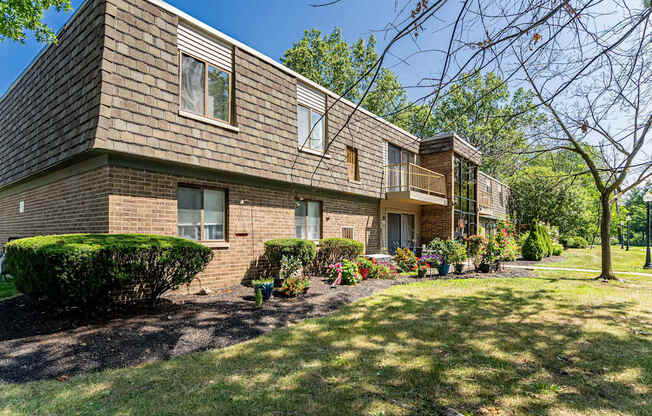 A row of houses with green lawns in front.