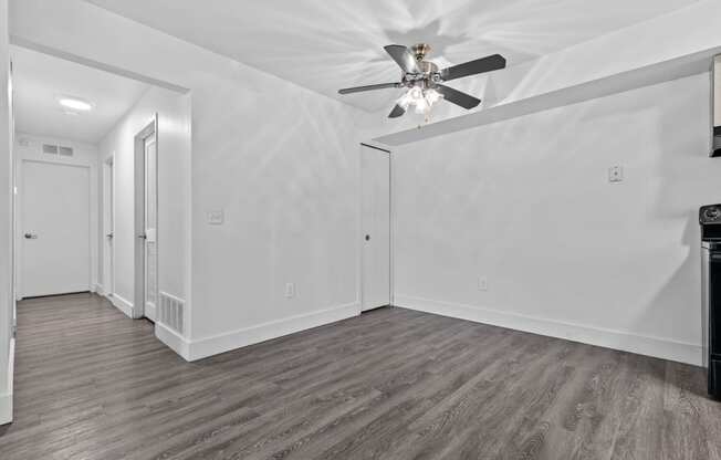 a bedroom with white walls and a ceiling fan