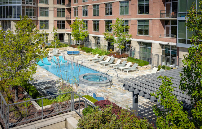 A pool surrounded by a patio and trees.