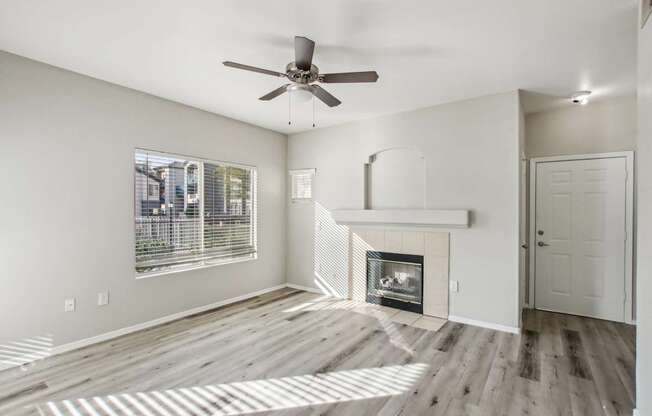 A room with a fireplace and a ceiling fan.