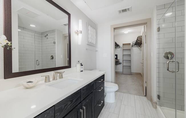 a white bathroom with a large mirror and a toilet