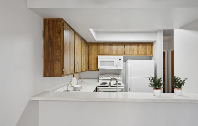 Model Kitchen with Dark Wood Cabinets and Wood-Style Flooring at Creek at 2645 Apartments located in Sacramento, CA.