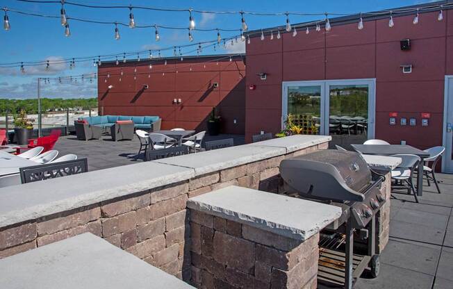 A red building with a grill on the patio.