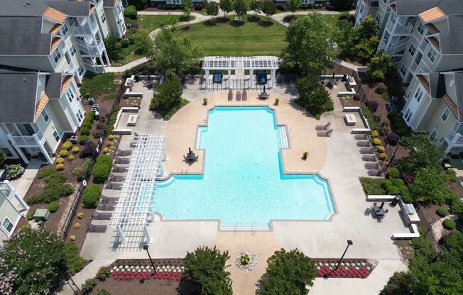 an aerial view of the swimming pool and sundeck surrounded by residential buildings at Fenwyck Manor Apartments