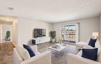 A living room with white furniture and a large window.
