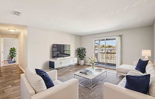 A living room with white furniture and a large window.