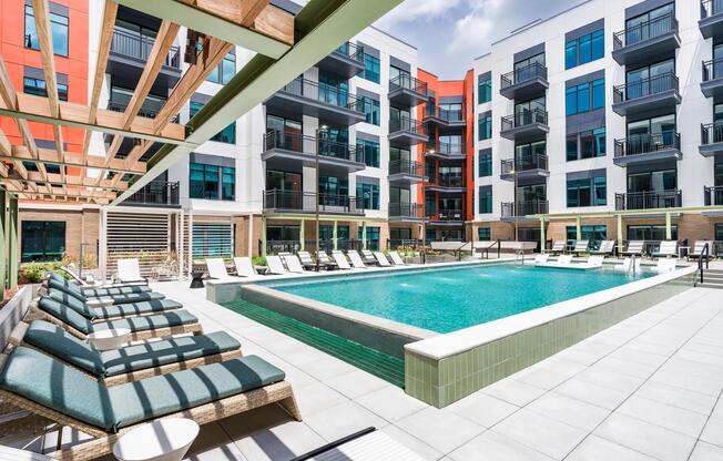 Resort-style pool with in-water loungers, shaded seating, and a spacious sundeck for warm-weather relaxing.