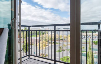 A balcony with a glass door and a black railing. at The Platform, Kent, Washington