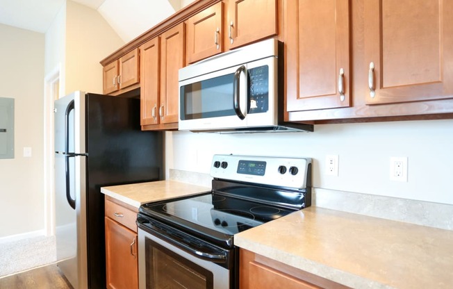 a kitchen with wood cabinets and black appliances and a black refrigerator