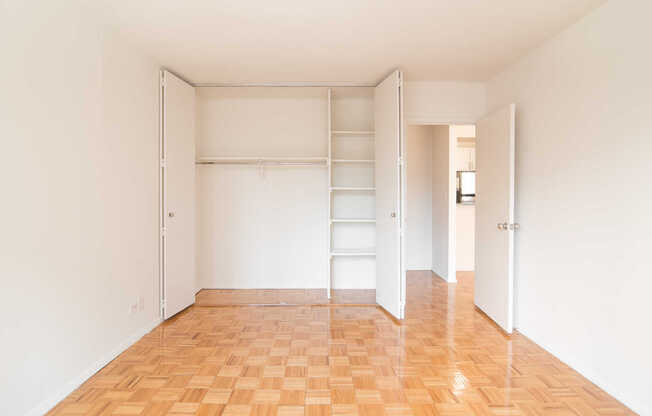 Bedroom with Wood Parquet Flooring and Over-sized Closet