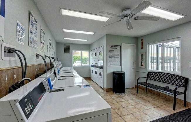 A row of washing machines are lined up in a laundromat.