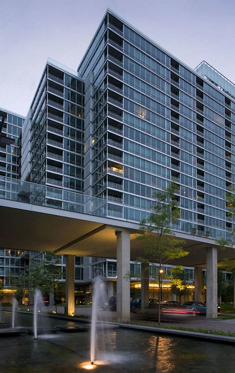 A modern building with a fountain in front.