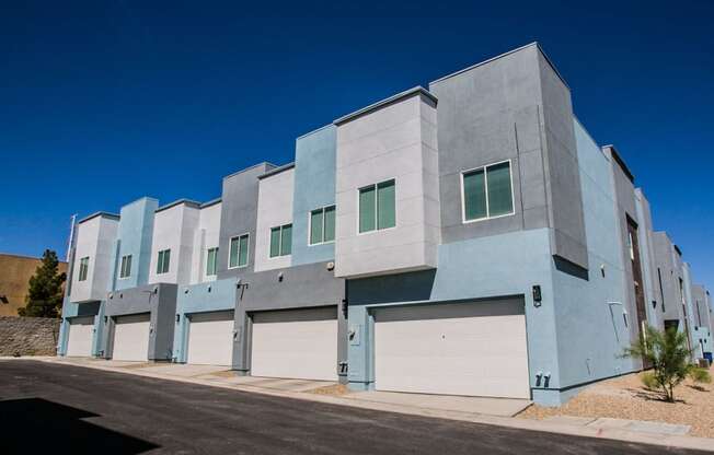 the exterior of a building with white and blue doors