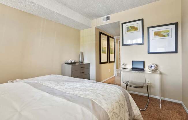 A bedroom with a bed, desk, and chair.