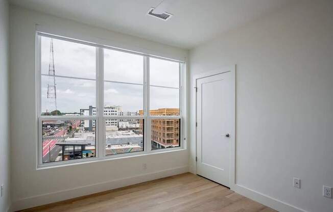A room with a view of the city through large windows.