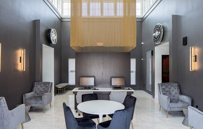 a large room with a round table with chairs and a chandelier above it