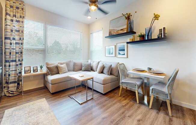A living room with a couch, chairs, and a dining table.