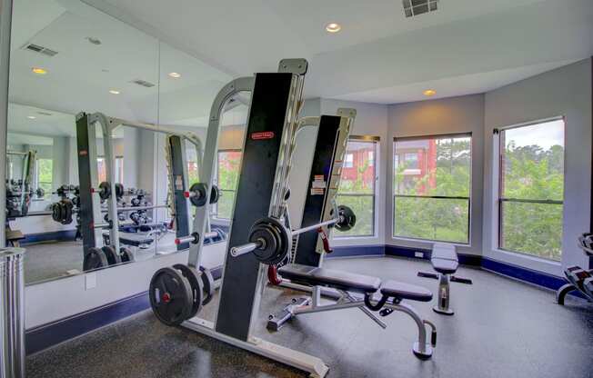 a home gym with weights and a row of windows