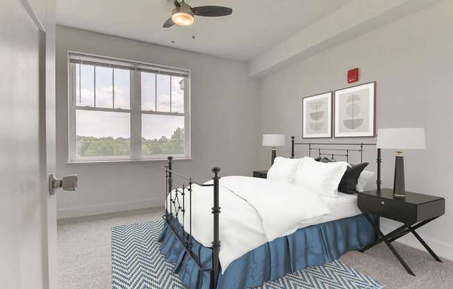 A bedroom with a bed, nightstand, ceiling fan and a window at Dodson Pointe Apartment Homes, Rogers