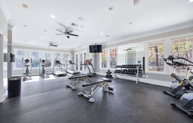 the home gym has plenty of exercise equipment and windows