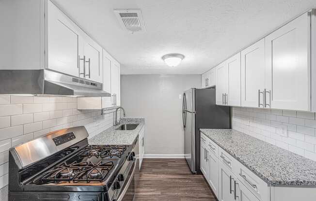 a kitchen with white cabinets and a stove and refrigerator