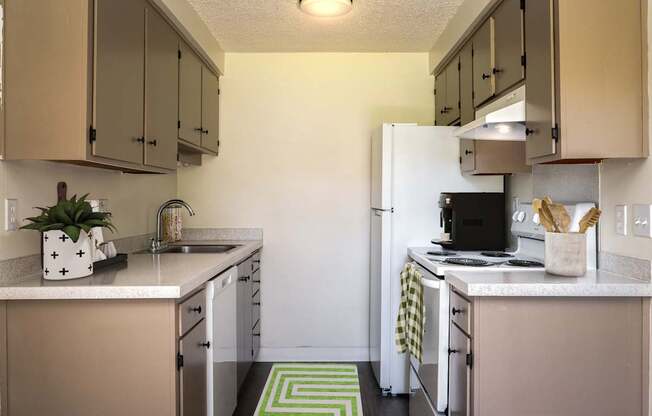 A kitchen with a white fridge and beige cabinets.