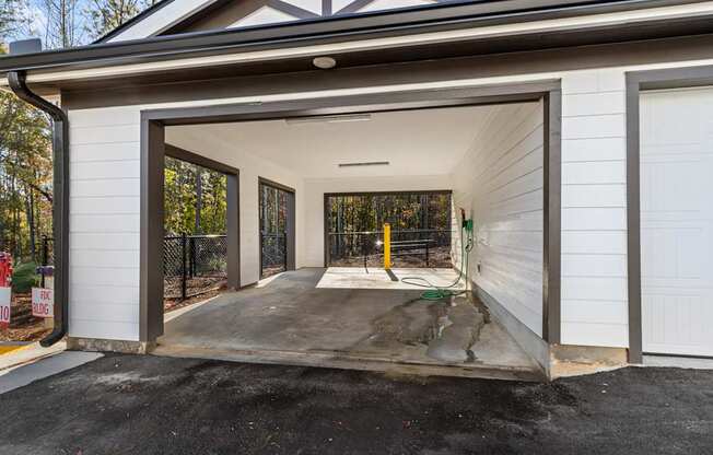 A garage with a white door is open, revealing a concrete floor and a yellow object inside.