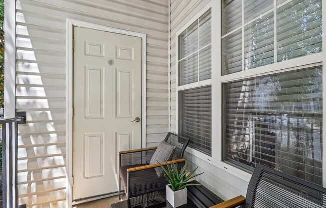 covered patio with a white door and chairs