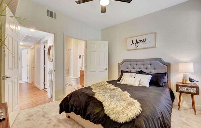 A bedroom with a large bed and a ceiling fan.