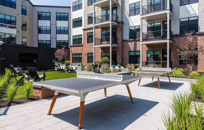 A table tennis table is in the middle of a courtyard.